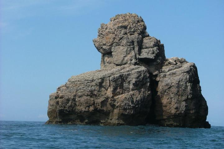 a rocky island in the middle of a body of water