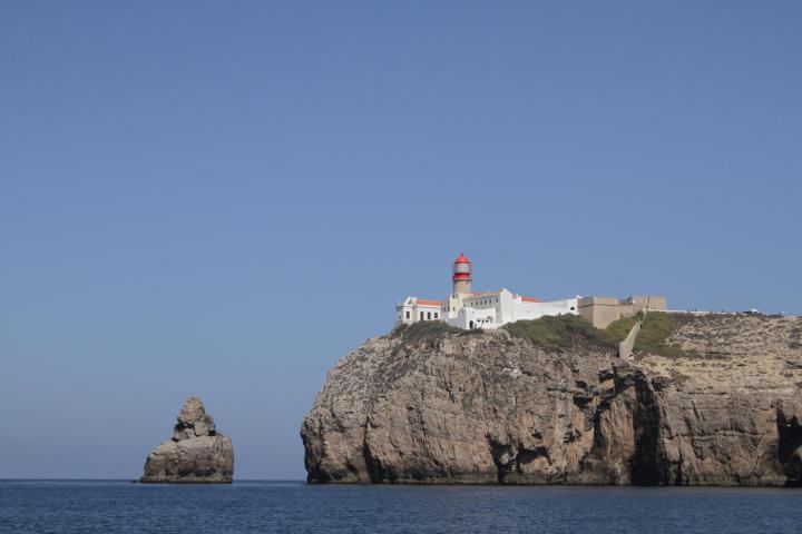 a building near a cliffside near a body of water