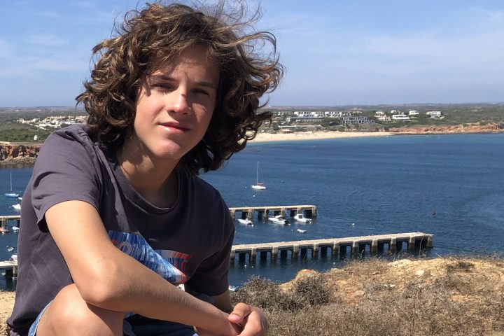 a person sitting on a beach near a body of water