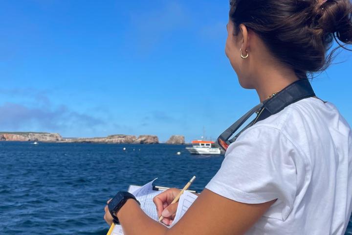 a man standing next to a body of water